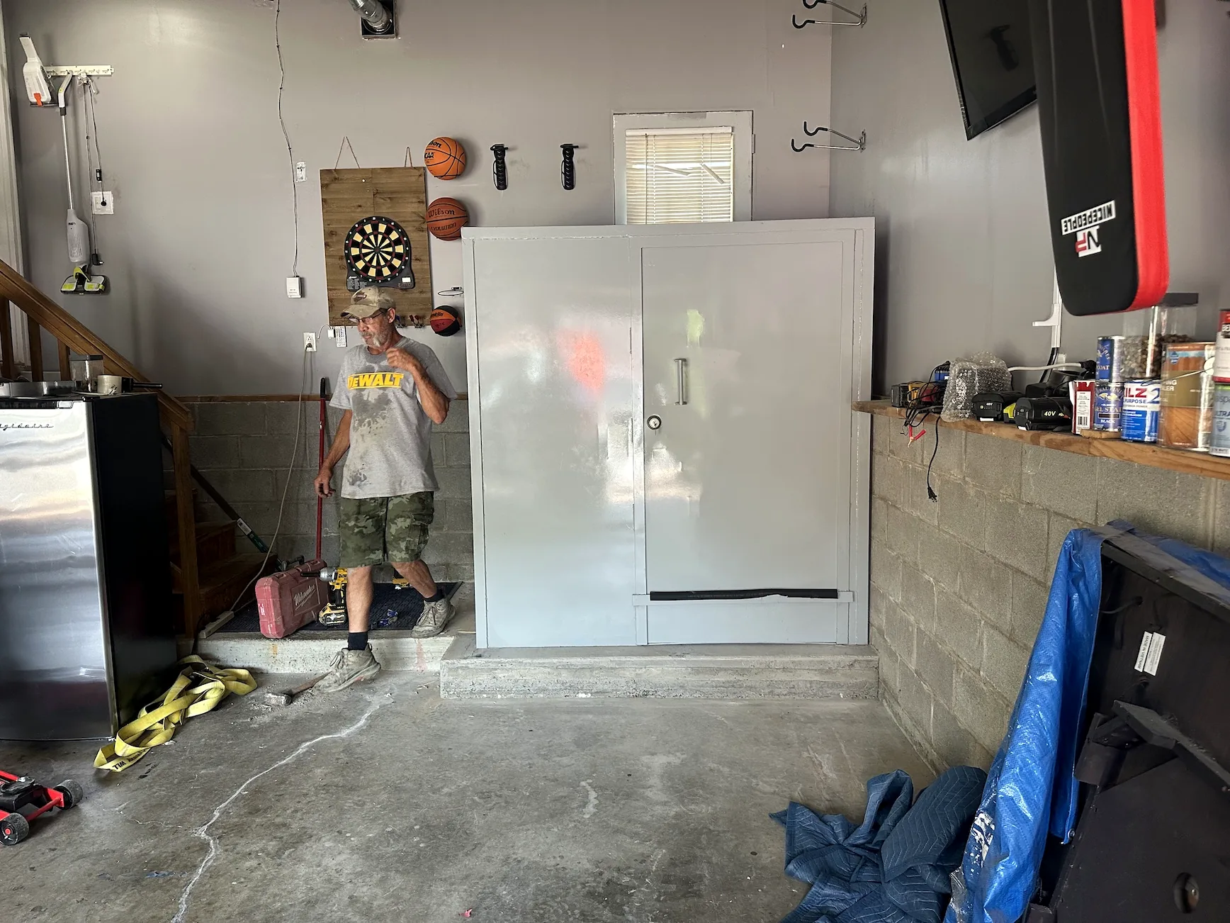Front view of an above-ground tornado safe room installed in a residential garage