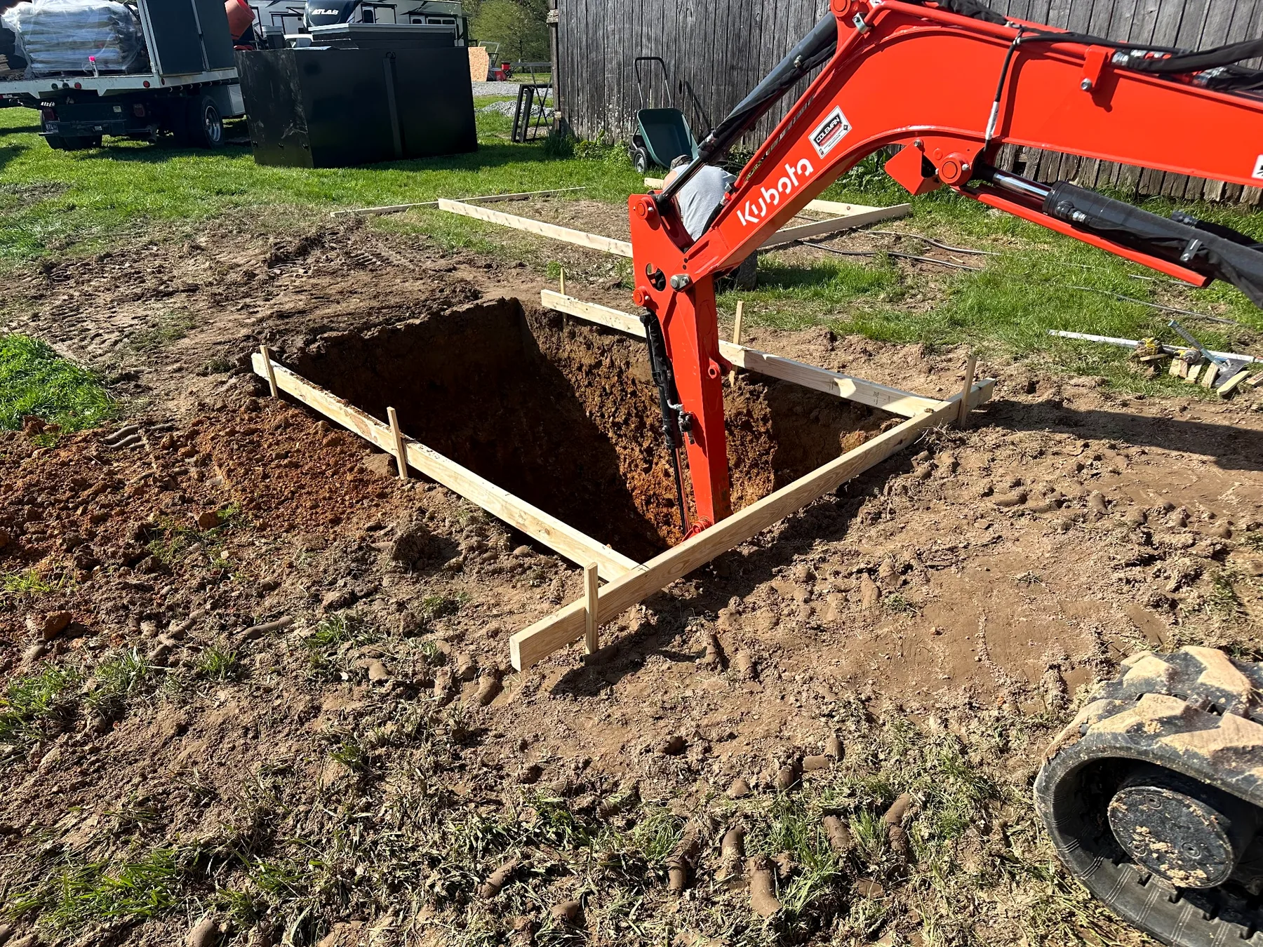 Excavator preparing a site for an outdoor storm shelter installation in Tennessee