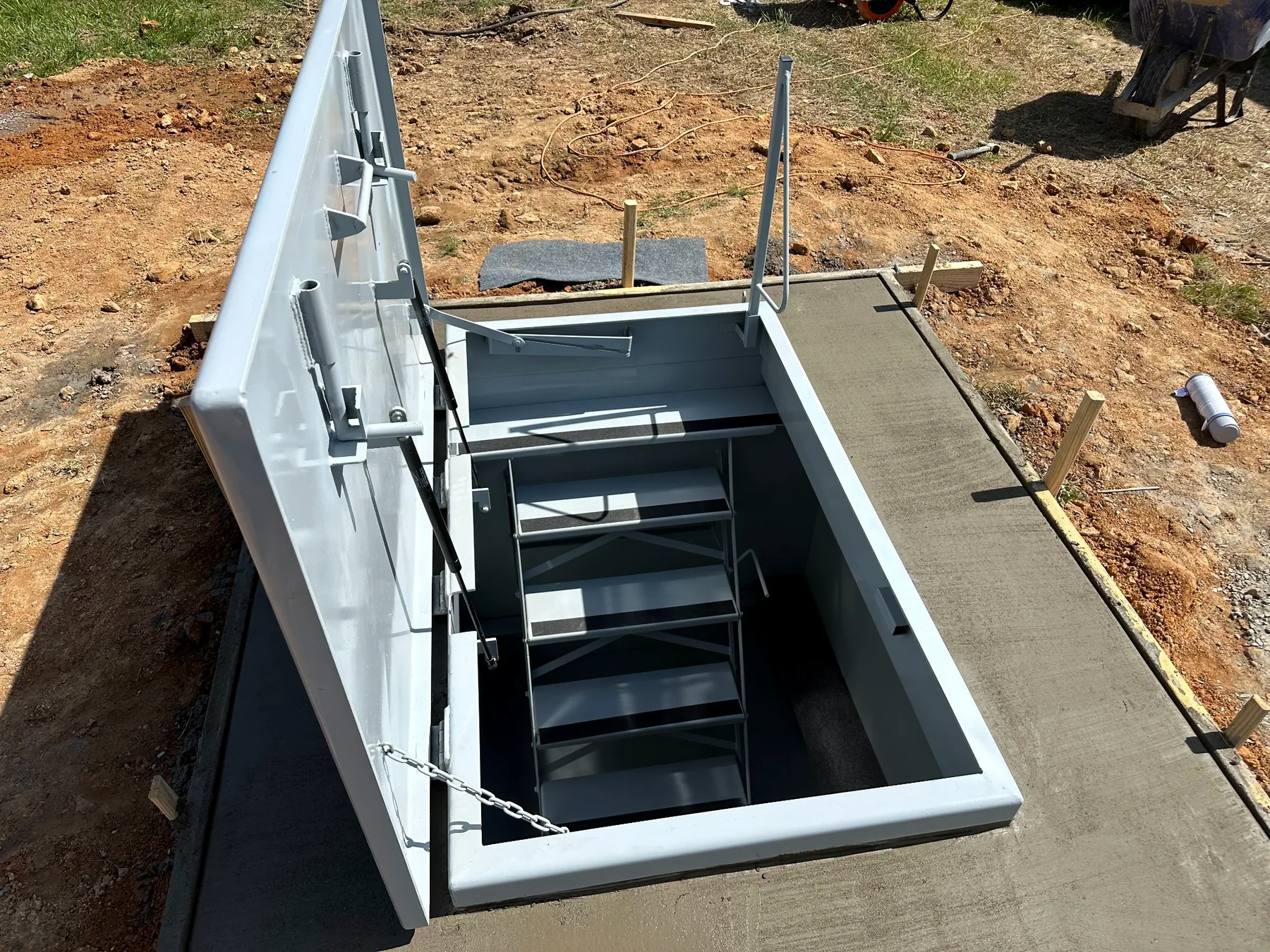 Open outdoor tornado storm shelter with stairs and seating installed in Tennessee